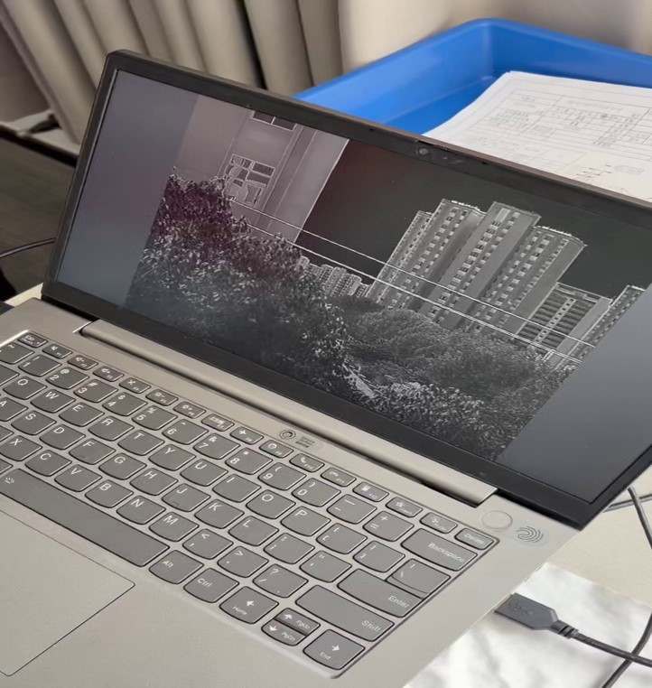 Real-world application of the 25-75mm all-chalcogenide zoom lens integrated with a thermal imaging system. Displays high-definition infrared imaging capabilities on a laptop, ideal for security monitoring, surveillance, and industrial inspection.


